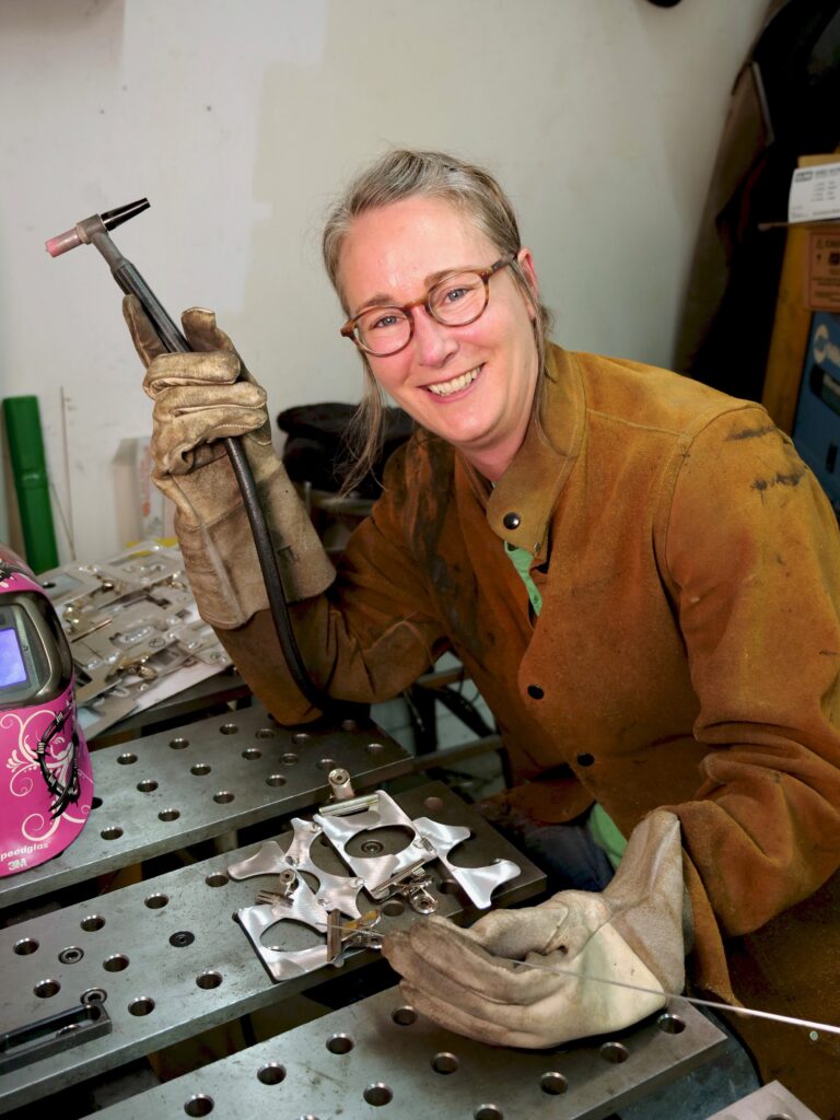Cherie Haney smiling for the camera at her welding station